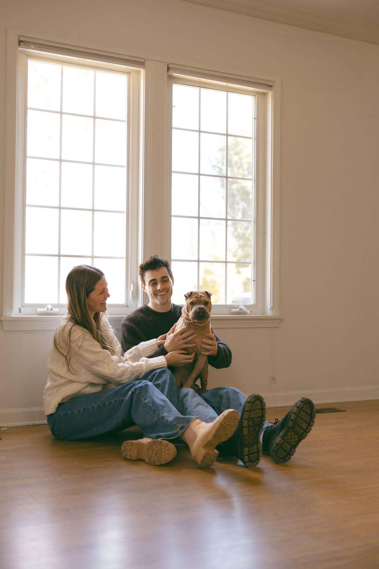 couple in new home with dog relaxing on the floor