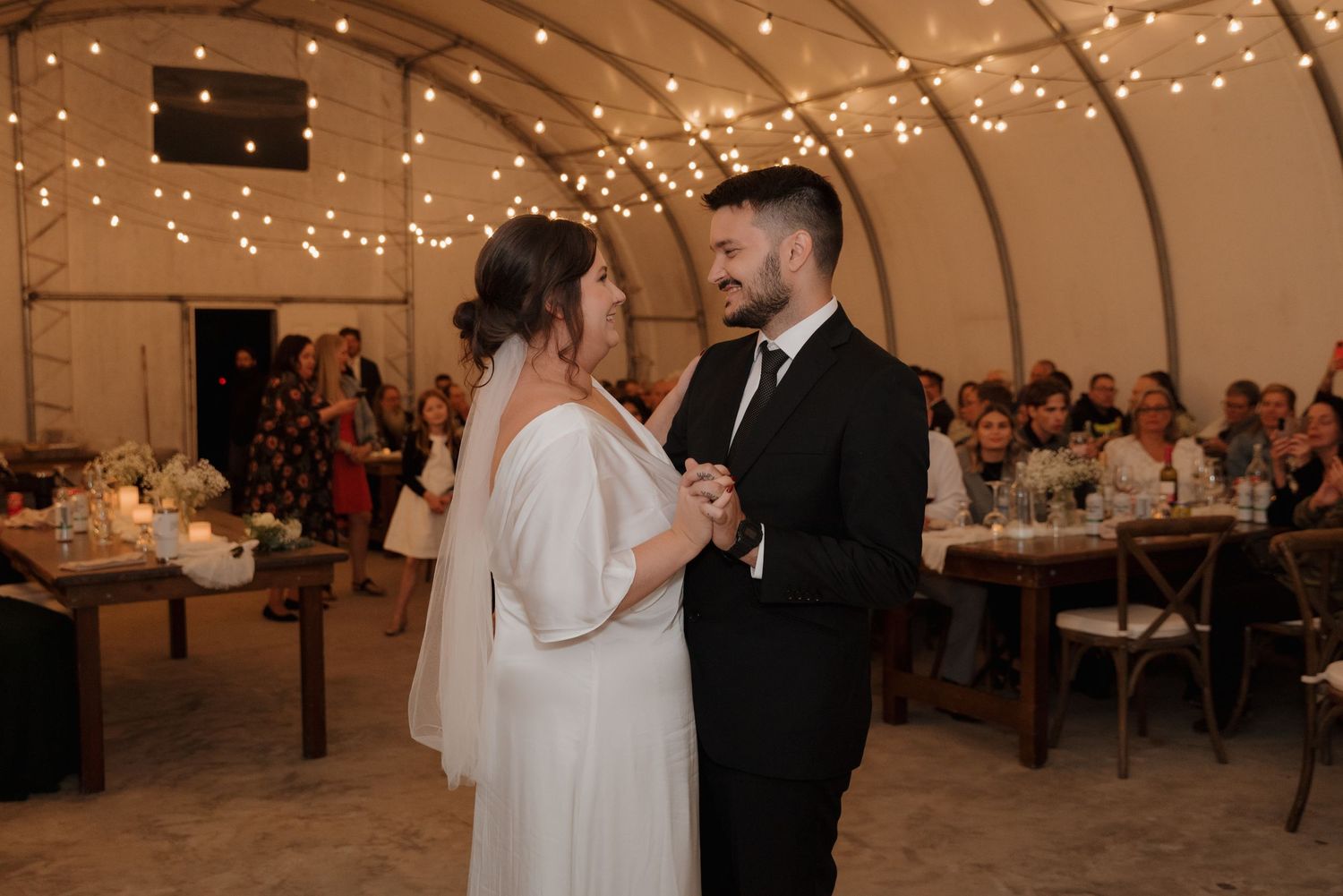 Couple sharing an intimate dance moment under warm lighting at their wedding reception.
