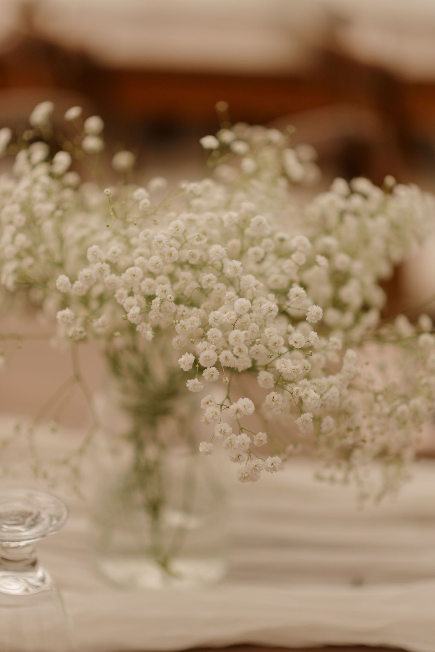 Delicate baby's breath flowers in glass vase create romantic vintage wedding centerpiece.