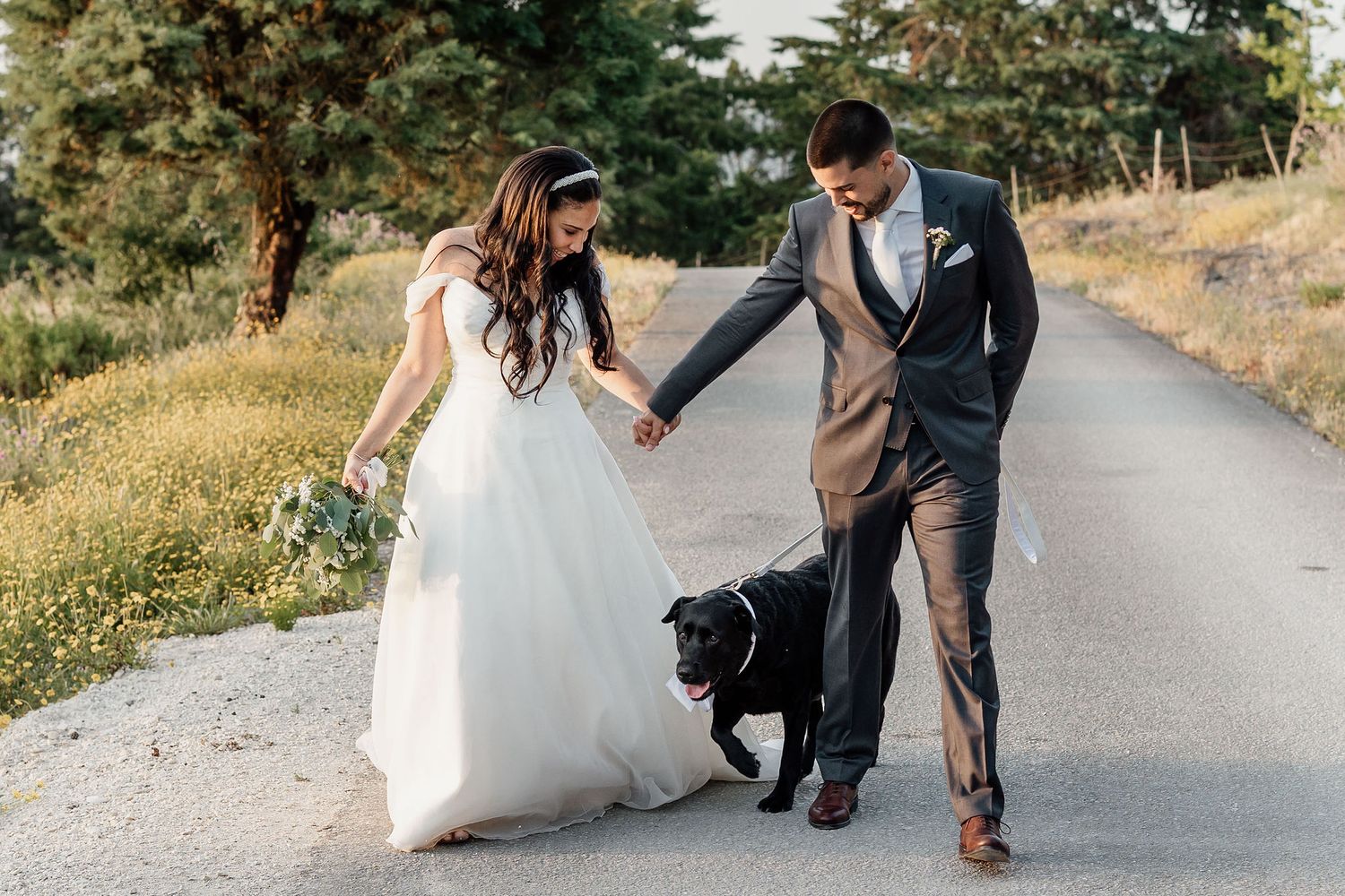 Intimate wedding portrait against a lush green hedge background.