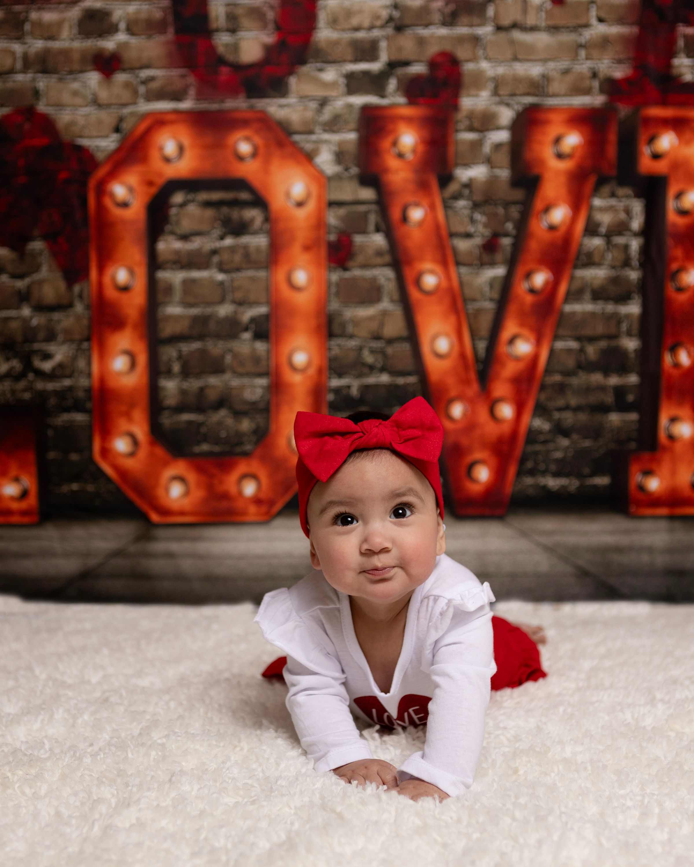 Festive Valentine's setup featuring bright red LOVE marquee letters on brick wall.