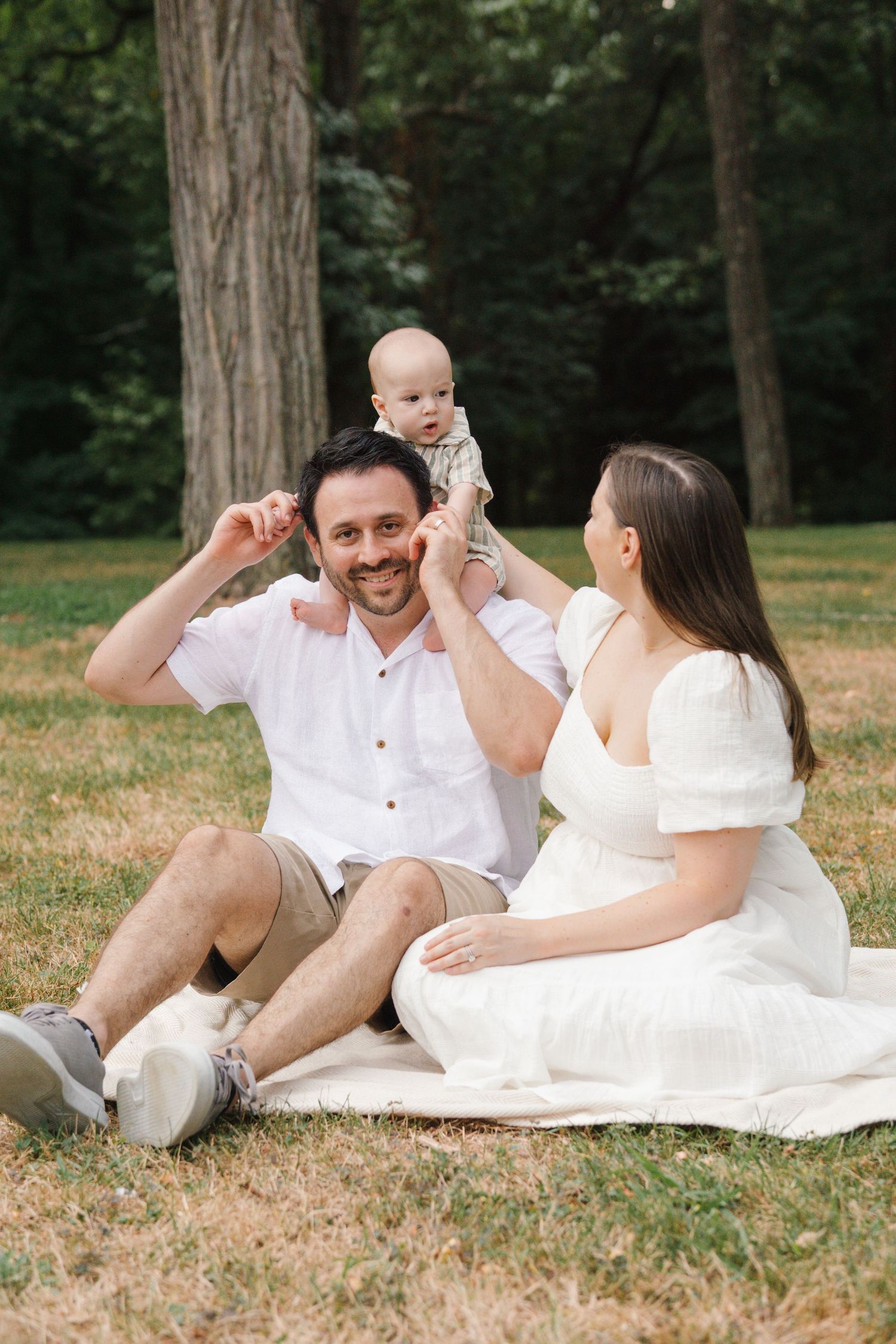 Candid family moment on a white blanket, capturing the joy of outdoor family photography in South Jersey.