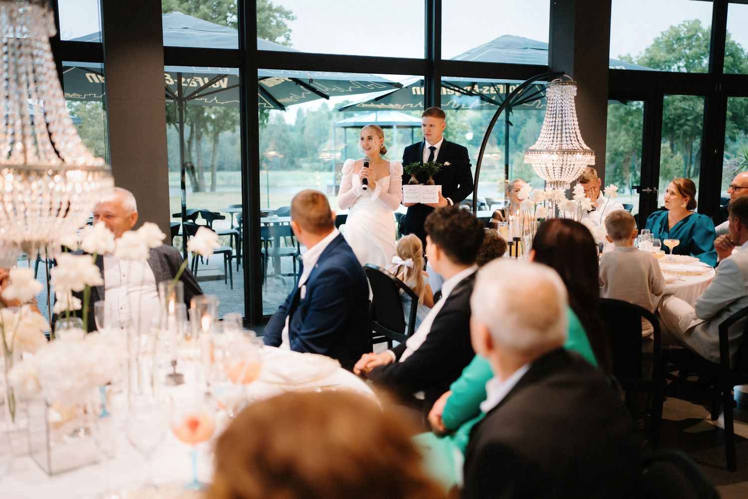 Elegant wedding reception venue with crystal chandeliers and large windows overlooking scenic views.