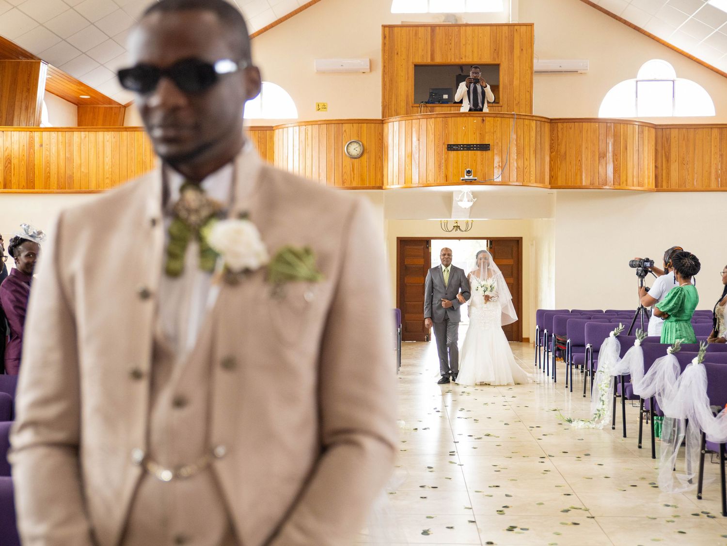 Interior view of a church wedding ceremony with wooden paneled walls.