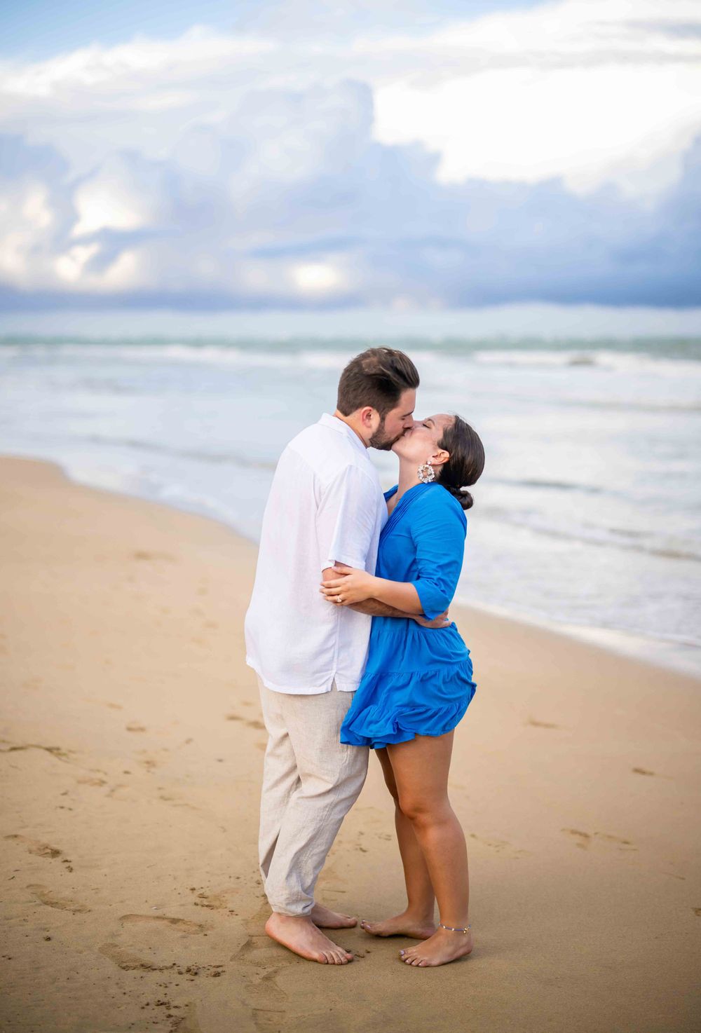 Romantic couple sharing an intimate moment while walking along a sandy beach.