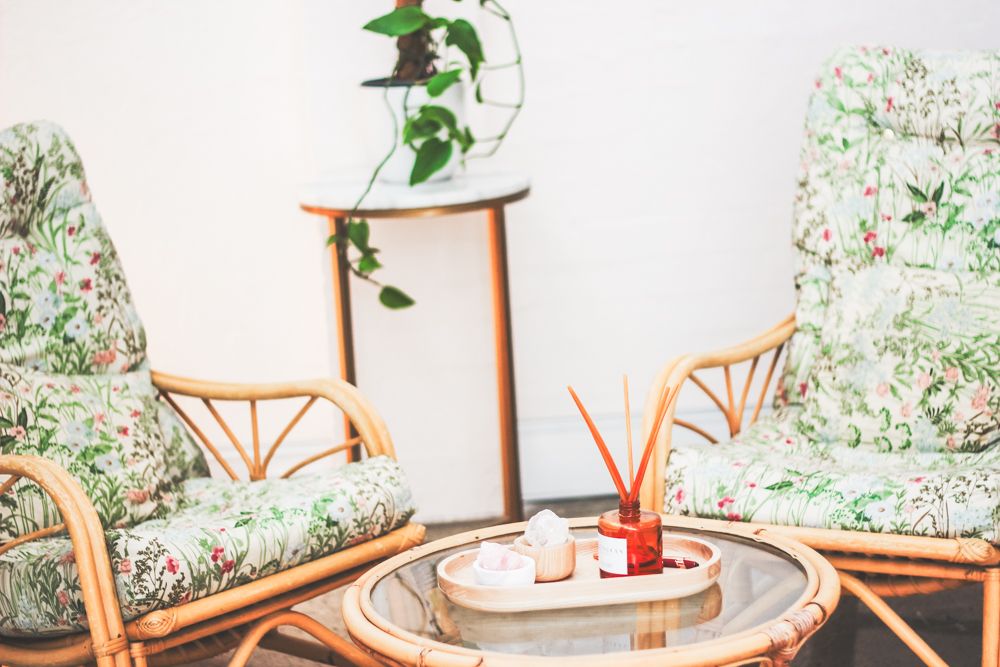 A massage therapist performs a therapeutic massage treatment in a relaxing room with colorful wall decor and plants.