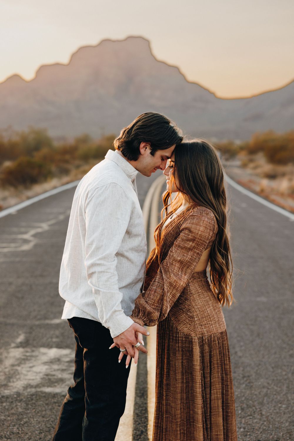 Touching foreheads during an embrace along a desert road in Phoenix Arizona.