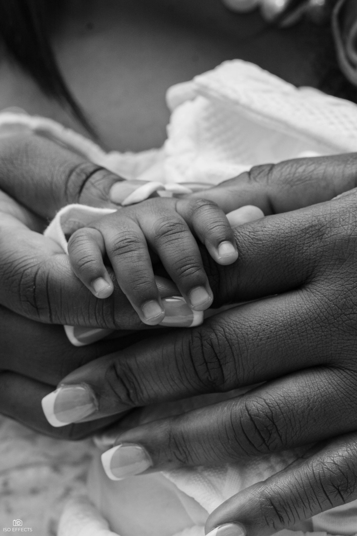 Black and white close-up of clasped hands showing care and comfort.