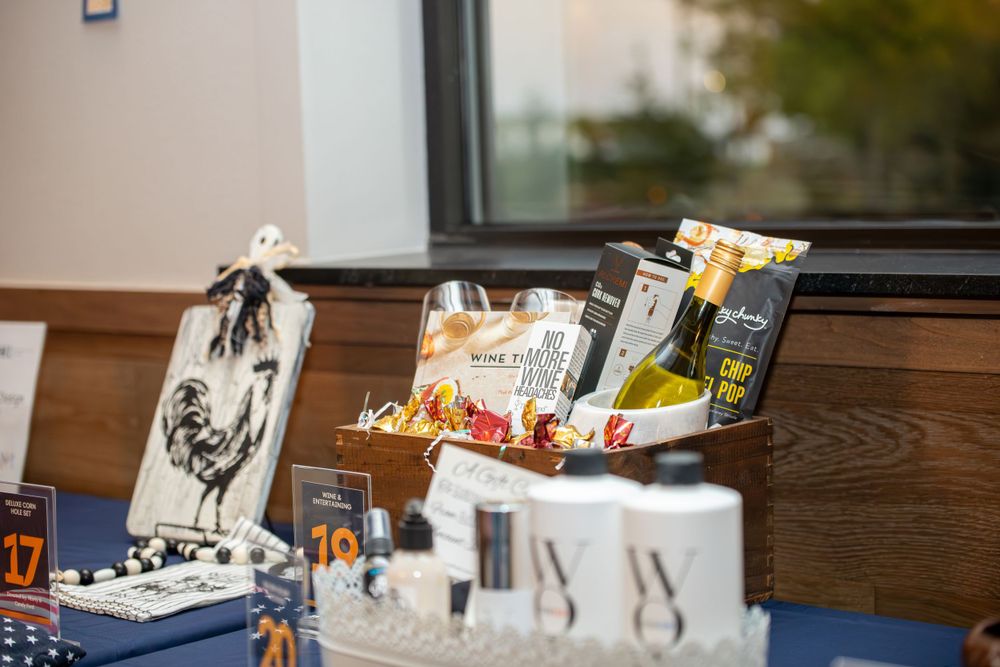 Snack bags and refreshments arranged on a wooden table at an event.