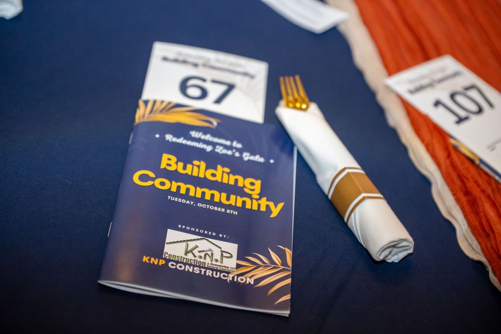 Printed materials and brochures about building community laid out on a blue tablecloth.