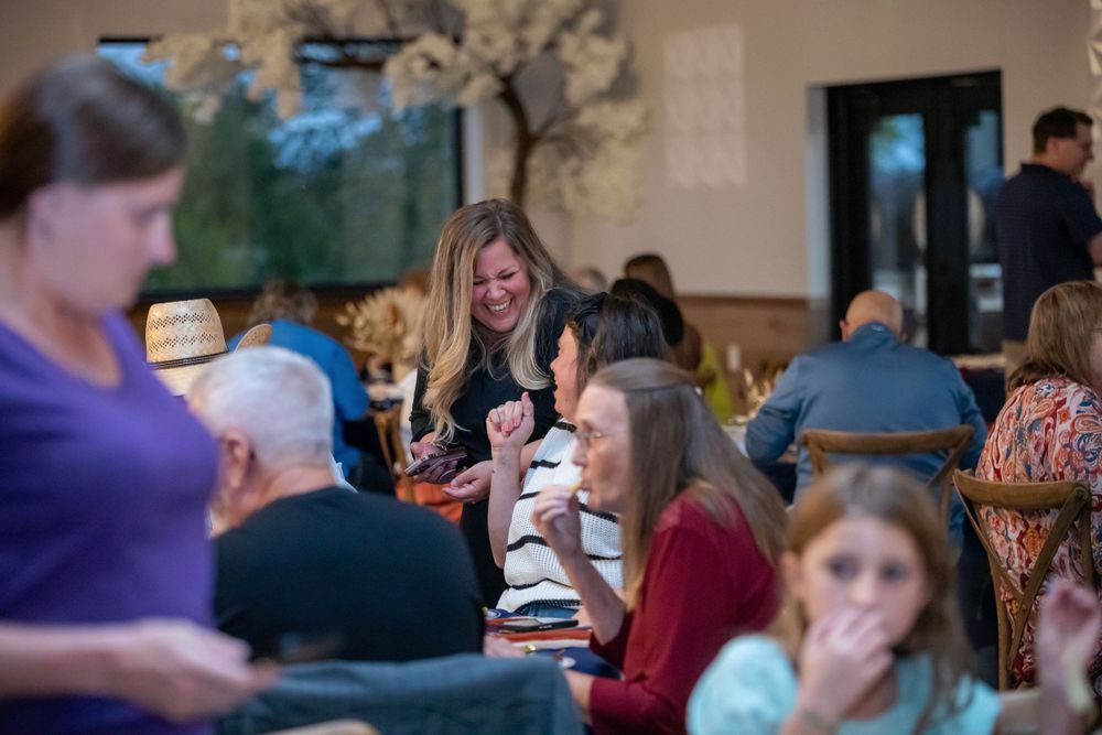 Crowd of people seated in a banquet hall during a social gathering.