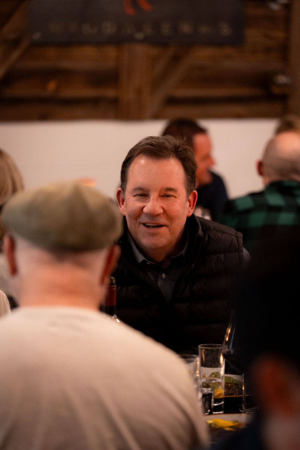 A candid moment captured at a social gathering with drinks and conversation.