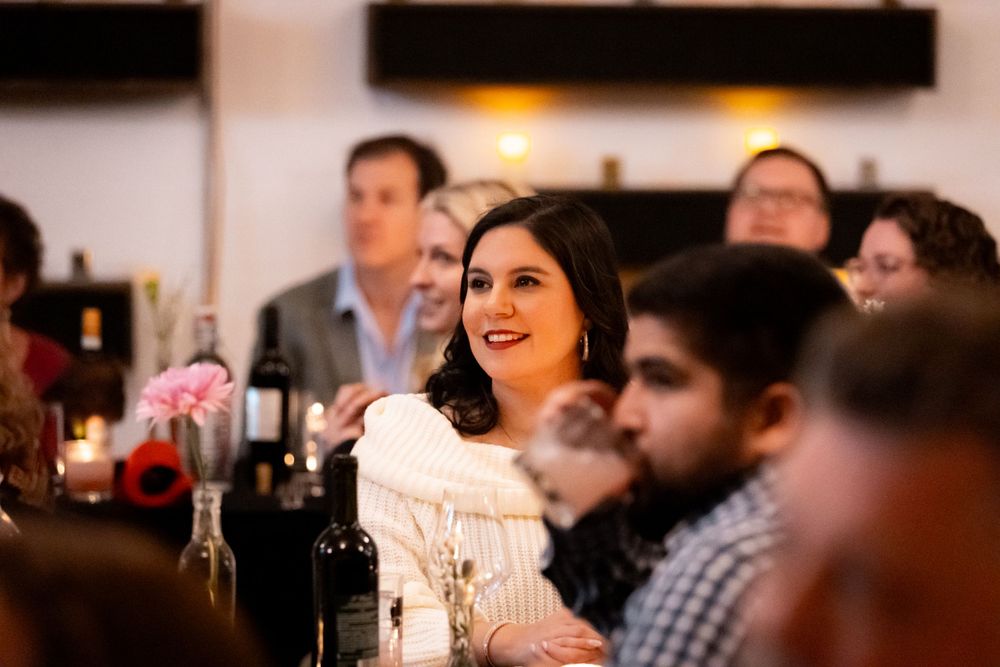 Diners enjoying conversation at an evening social event with ambient lighting.