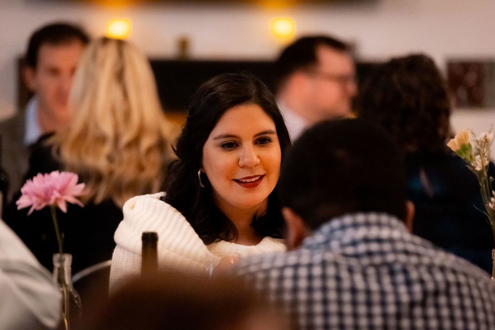 A warm and inviting dinner party scene with guests engaged in conversation.