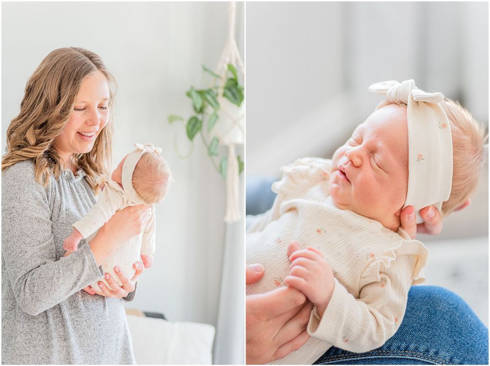 Mother in gray sweater holding newborn by window in bright modern room.