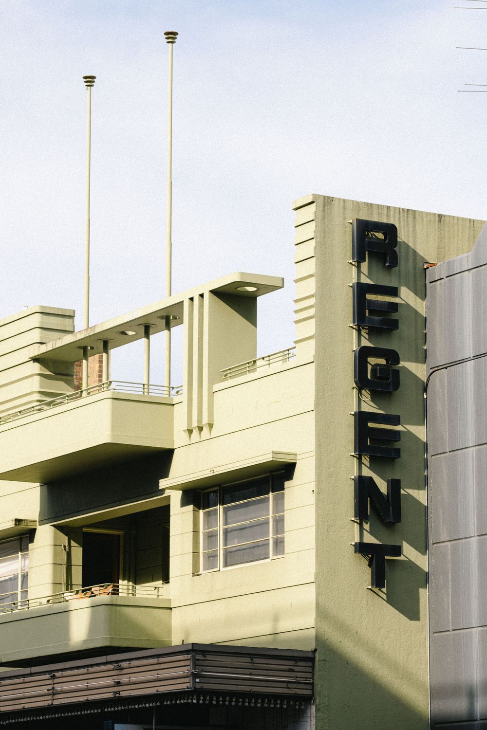 Modern architectural detail of a pale yellow building with geometric shapes and windows.
