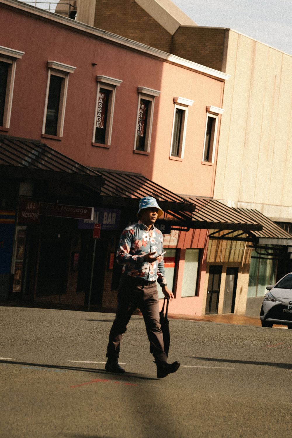 Two uniformed figures walk across an empty outdoor plaza with buildings in the background.