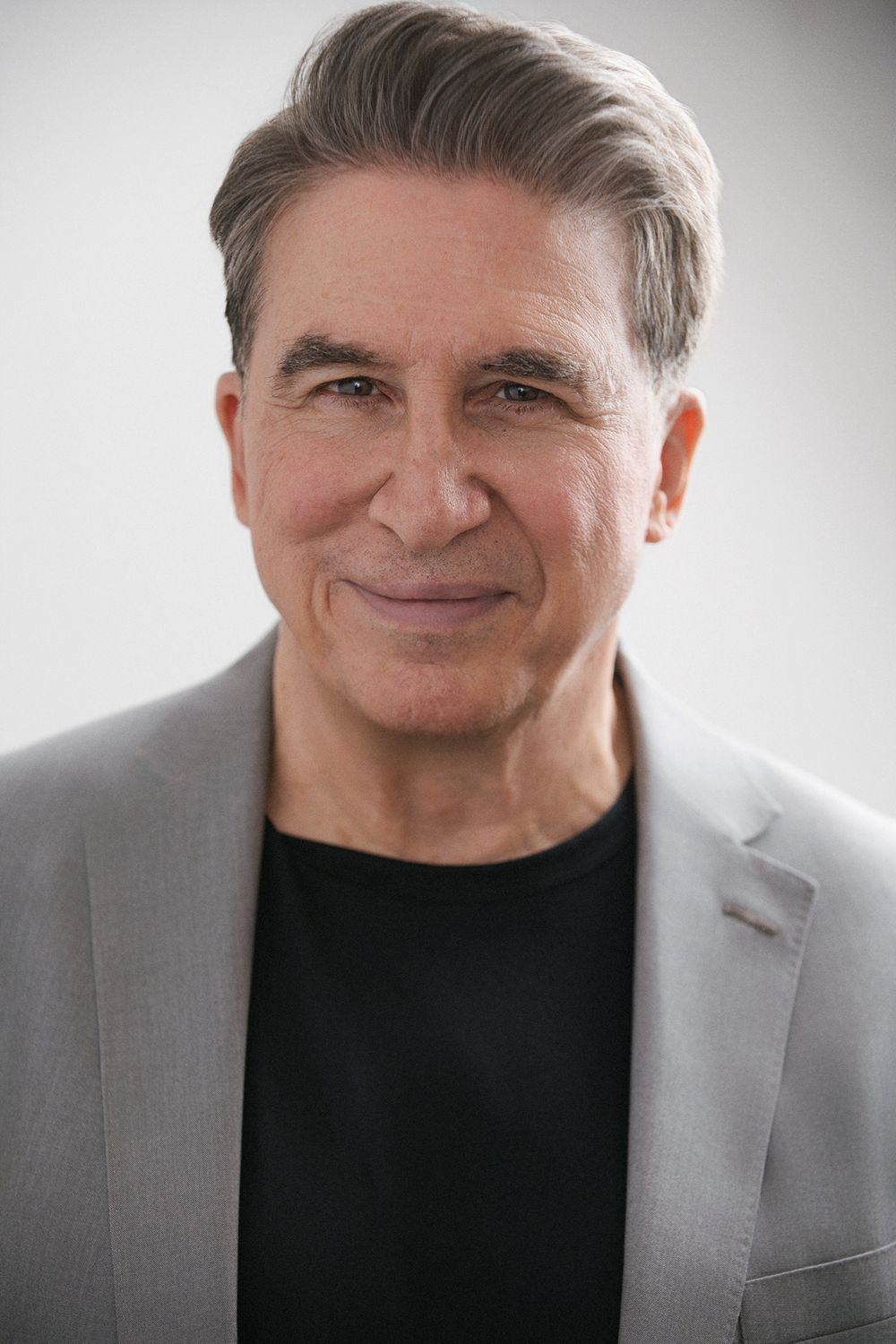 Professional studio actor headshot of an older male actor photographed against a solid color backdrop with cinematic lighting