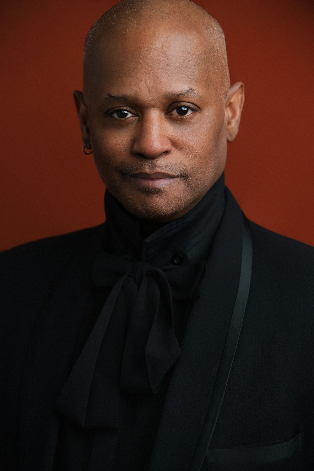 Professional studio actor headshot of a Black male actor photographed against a solid color backdrop with cinematic lighting.