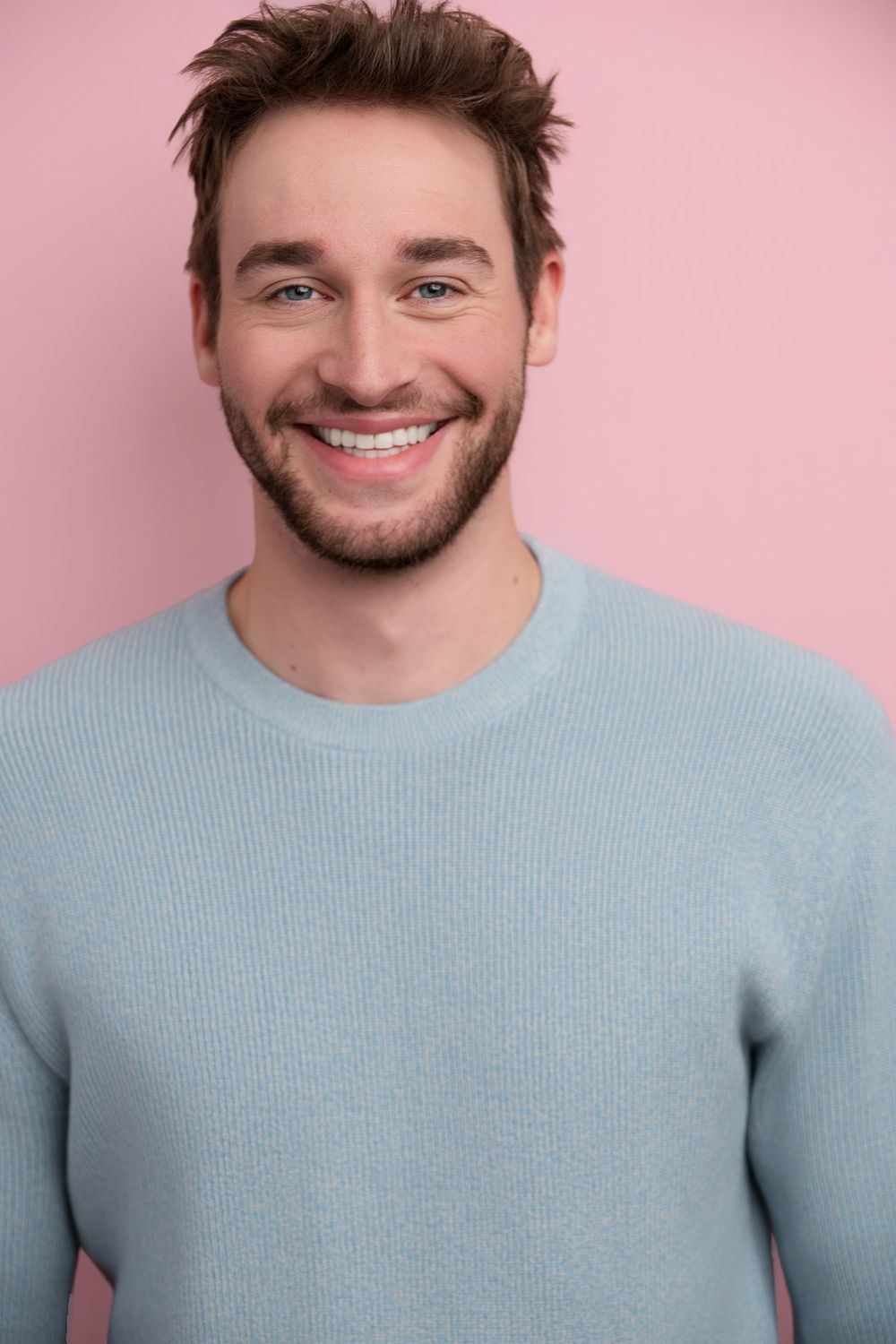 Studio headshot of an top Instagram influencer against a pink colored background, designed for commercial and on-camera casting submissions.