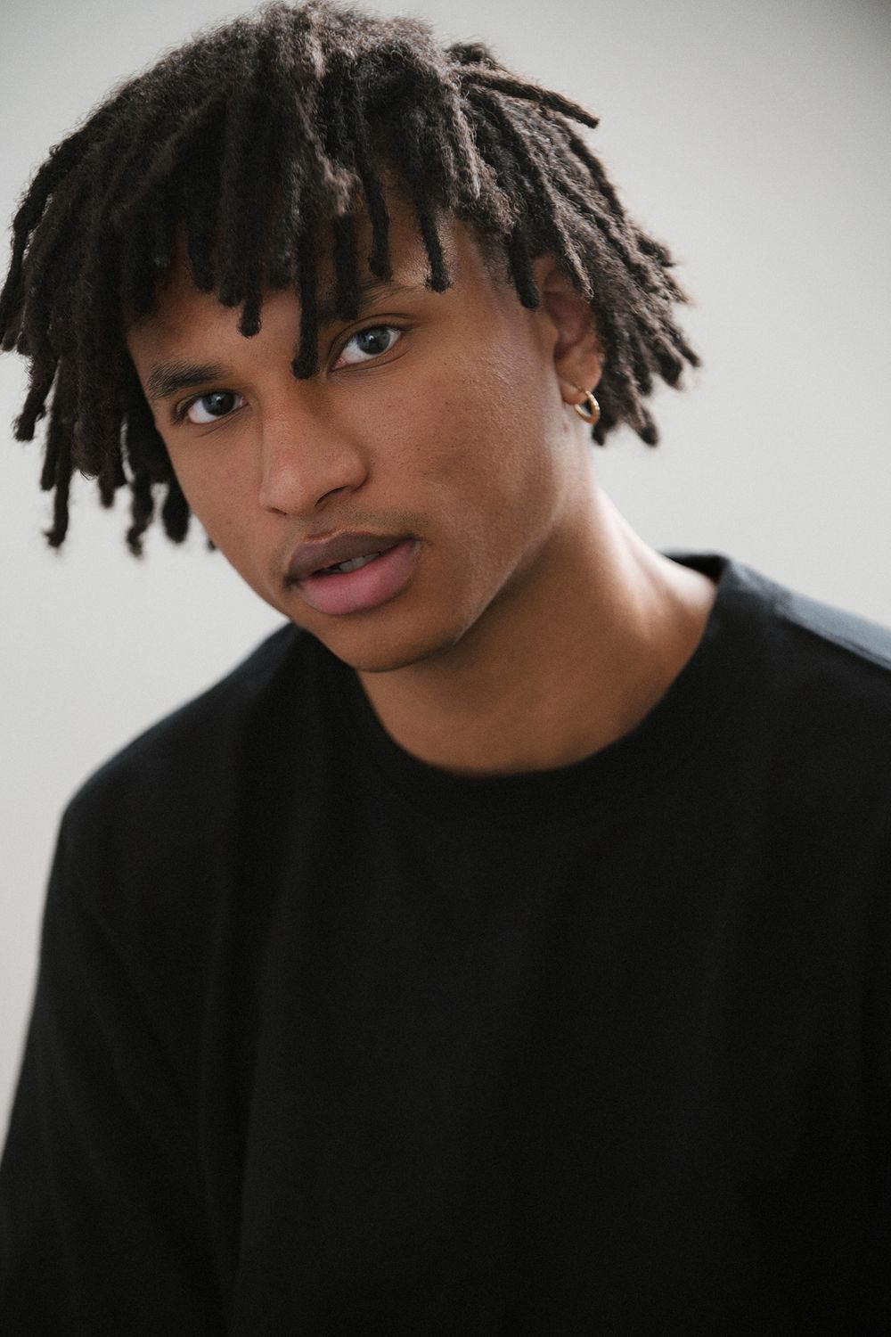 Professional studio actor headshot of a Black male actor photographed against a solid color backdrop with cinematic lighting.