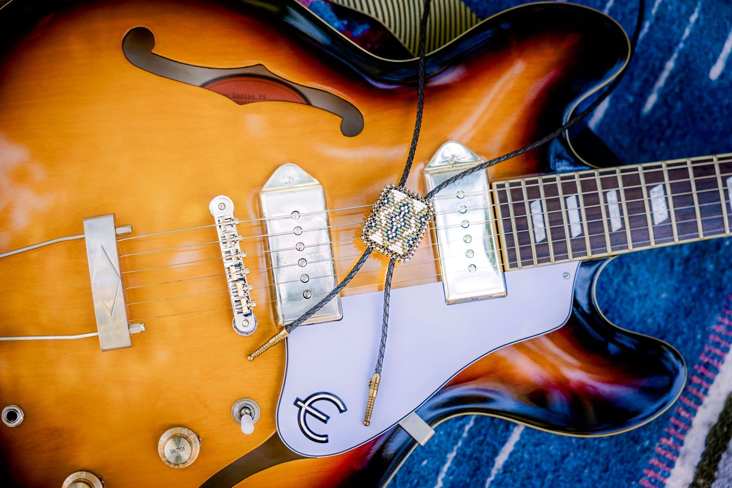 Close up of a sunburst semi-hollow body electric guitar with f-holes and two pickups in classic vintage styling.