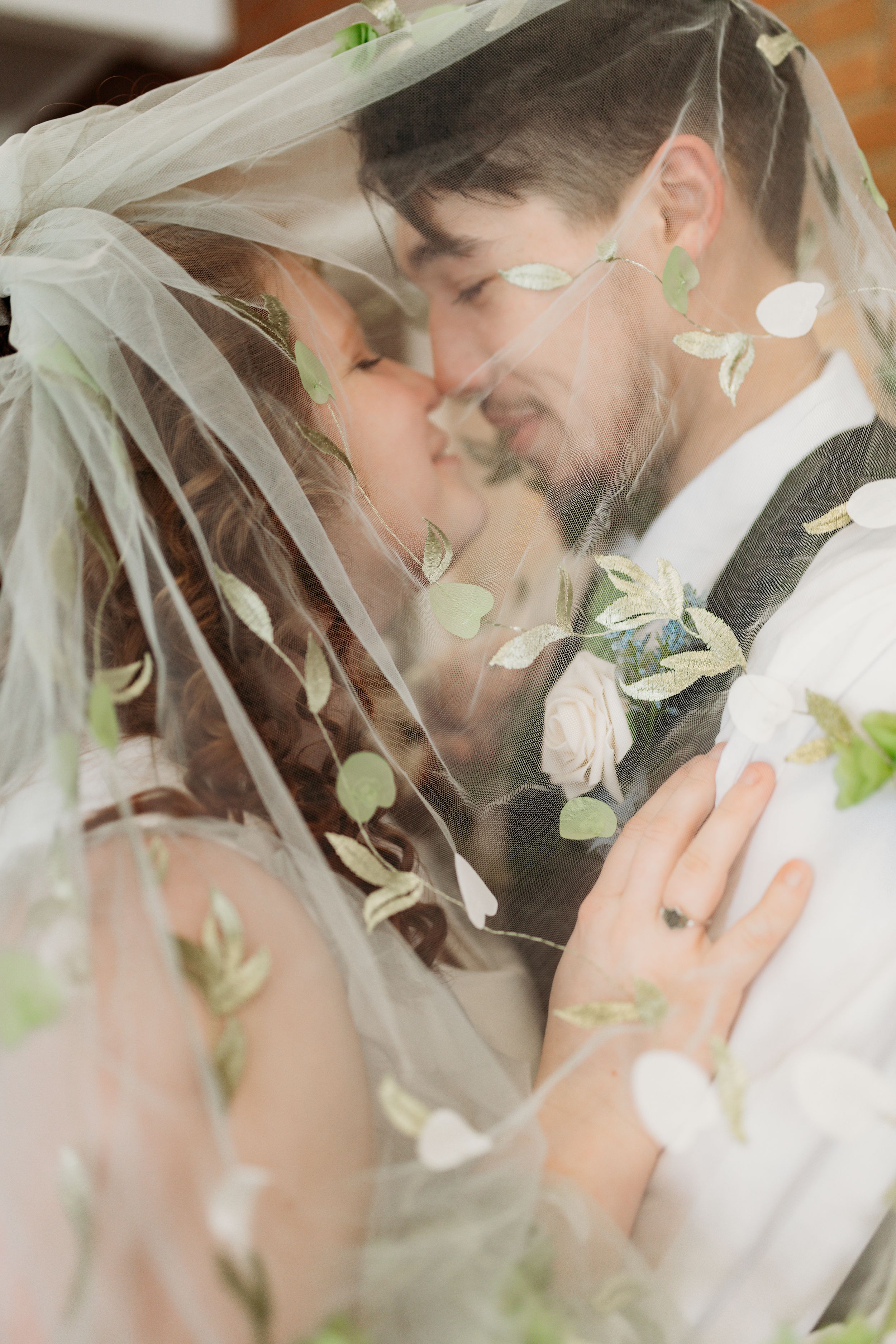 Romantic close-up through floral veil during wedding ceremony.