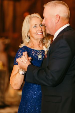 A couple shares an intimate dance moment at an elegant wedding reception.