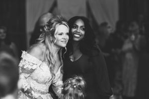 Wedding party members share joyful smiles during a black and white reception moment.