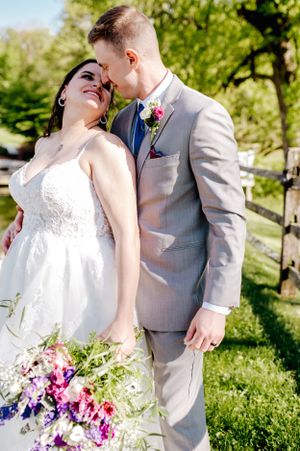 Romantic outdoor wedding portrait with couple embracing in spring garden setting.