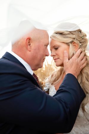 Intimate wedding moment captured in soft lighting with romantic pose.