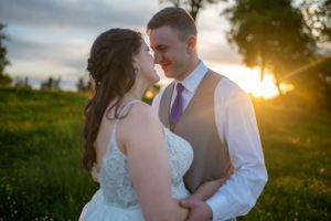 Intimate moment between newlyweds during golden hour in a meadow of wildflowers.