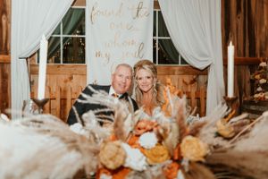 Intimate wedding reception moment at rustic venue with autumn-themed table decor.