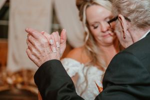 Close up of hands dancing during a wedding reception.