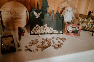 Wedding welcome table with decorative details including wooden signs and scattered cork pieces.