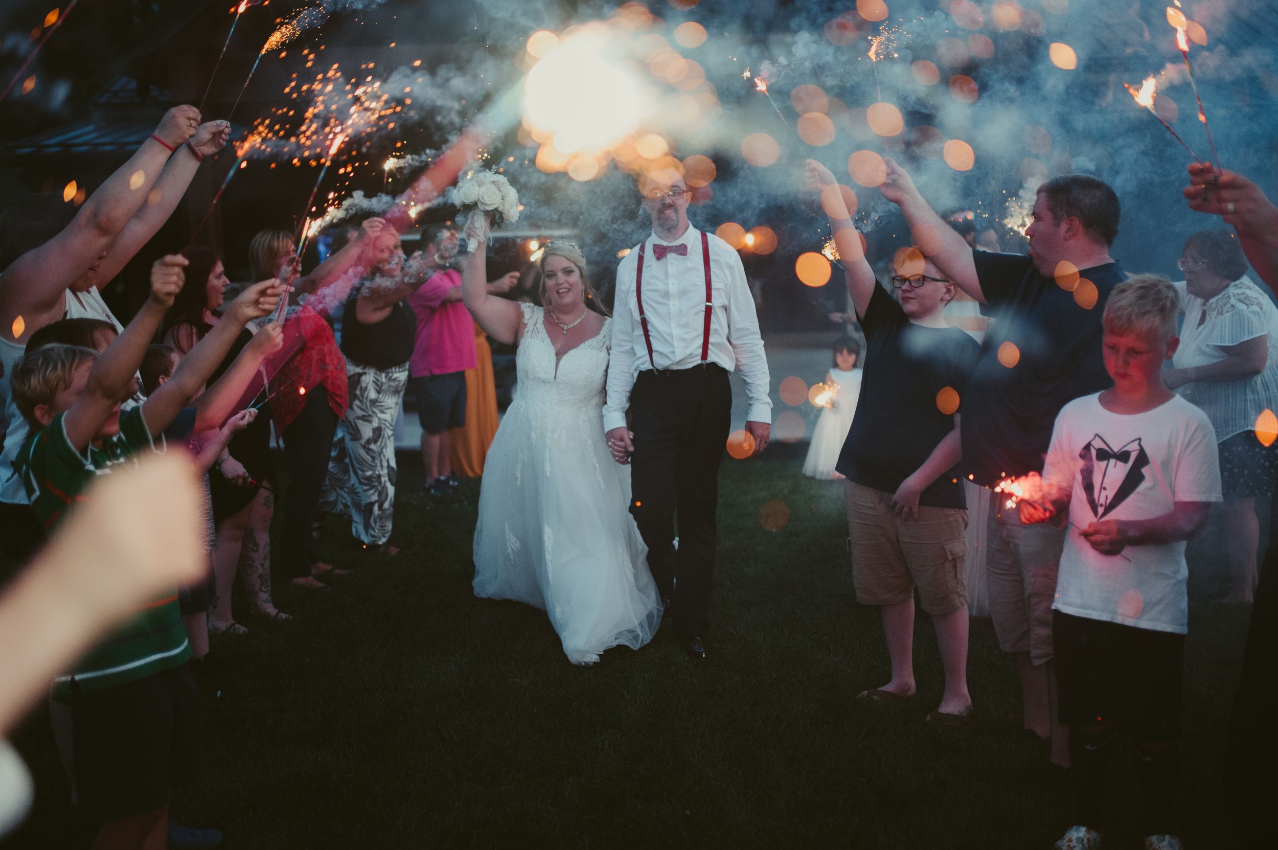 Sparkler exit celebration at night with wedding guests creating a magical atmosphere.