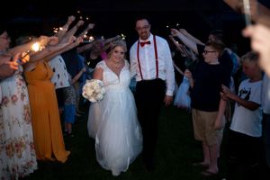 Evening sparkler send-off with guests forming a tunnel for the newlyweds.
