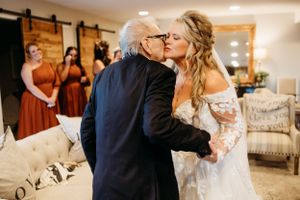 A tender moment shared during a wedding celebration in an indoor venue with rustic decor.