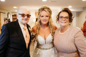 A celebratory wedding moment captured indoors with warm lighting and formal attire.