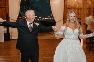 A joyful dance moment during a rustic barn wedding reception.