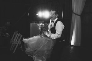 An intimate dance moment captured in black and white during a barn wedding reception.