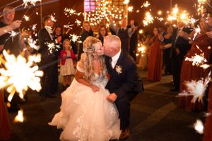 Newlyweds celebrate under magical sparklers during an evening reception.