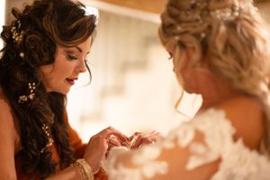 Intimate moment captured in warm lighting during wedding preparations.