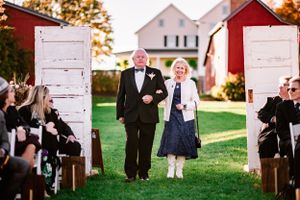 Wedding ceremony entrance with white doors and outdoor garden setting.