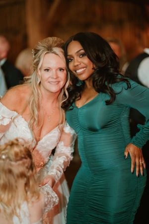 Wedding celebration features guests in elegant attire enjoying festivities inside rustic venue.