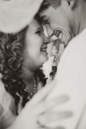 Black and white intimate portrait of joyful couple sharing a close moment.