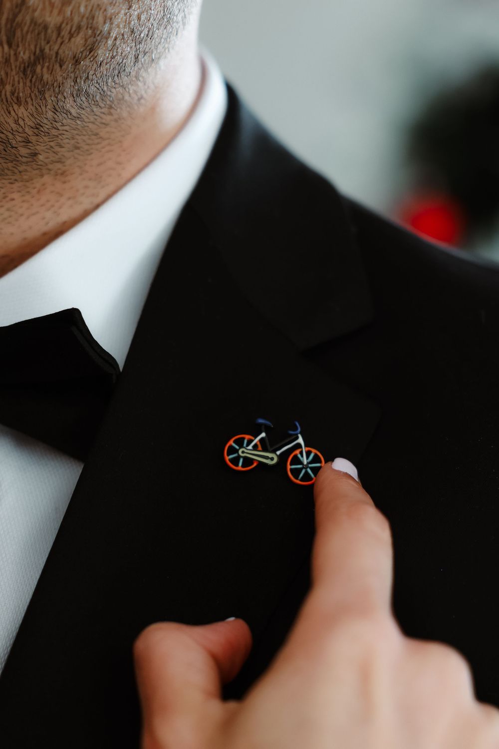 Close-up of bicycle lapel pin on black tuxedo jacket.
