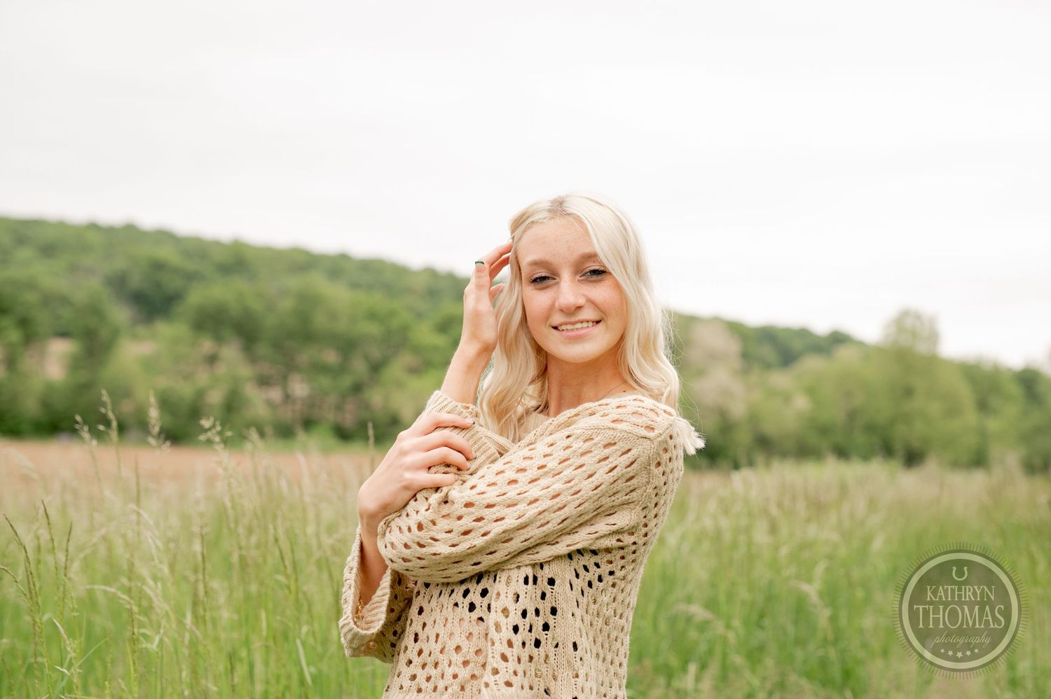 Candid countryside photo showing cream crochet sweater and casual denim style.