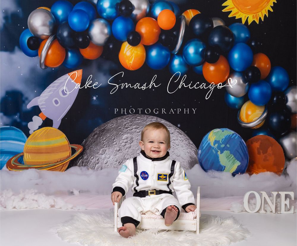 Baby during astronaut-themed cake smash in Chicago IL studio featuring planets, rockets, and space-inspired decor for first birthday.
