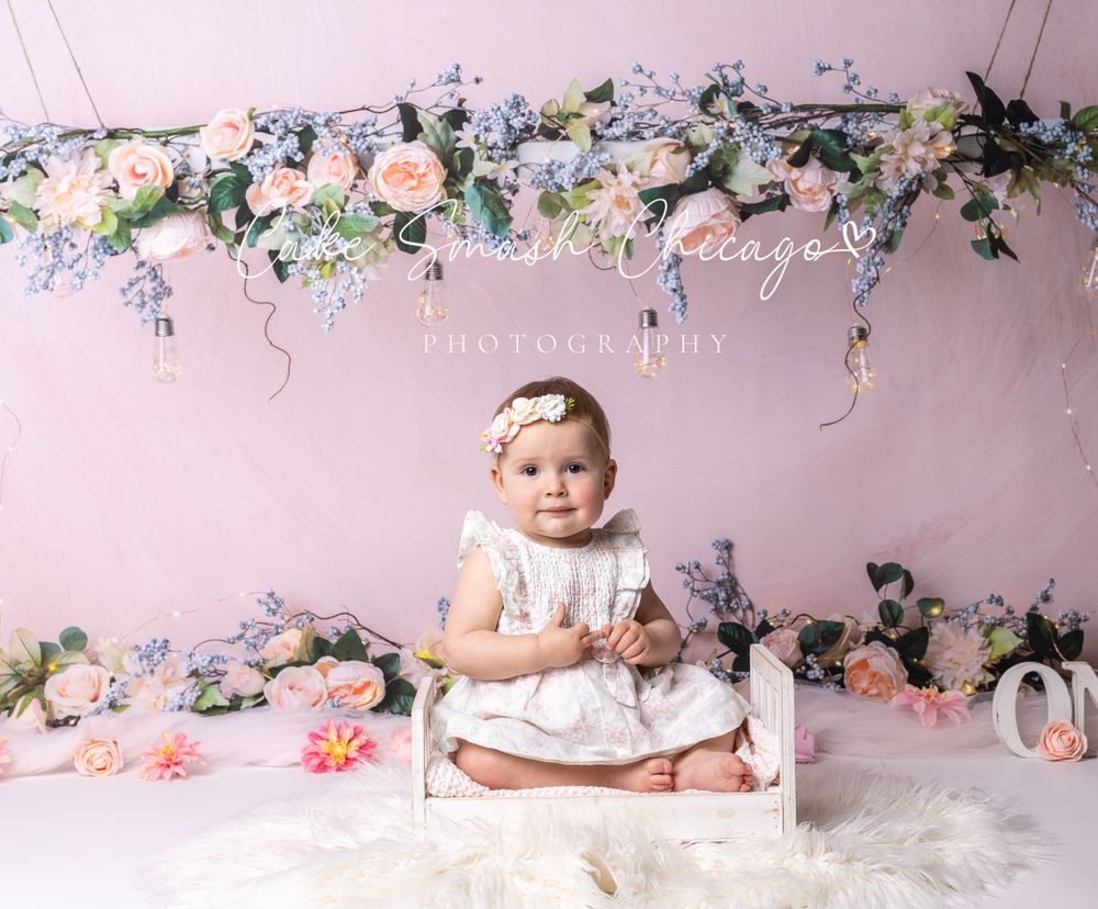 Baby during boho-themed cake smash in Glenview IL studio featuring soft floral decor, pastel tones, and elegant setup for first birthday.